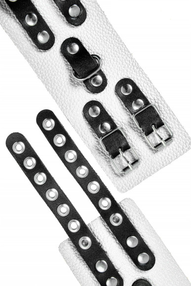 Бело-черные наручники с двумя ремешками и люверсами Бело-черные наручники с двумя ремешками и люверсами
